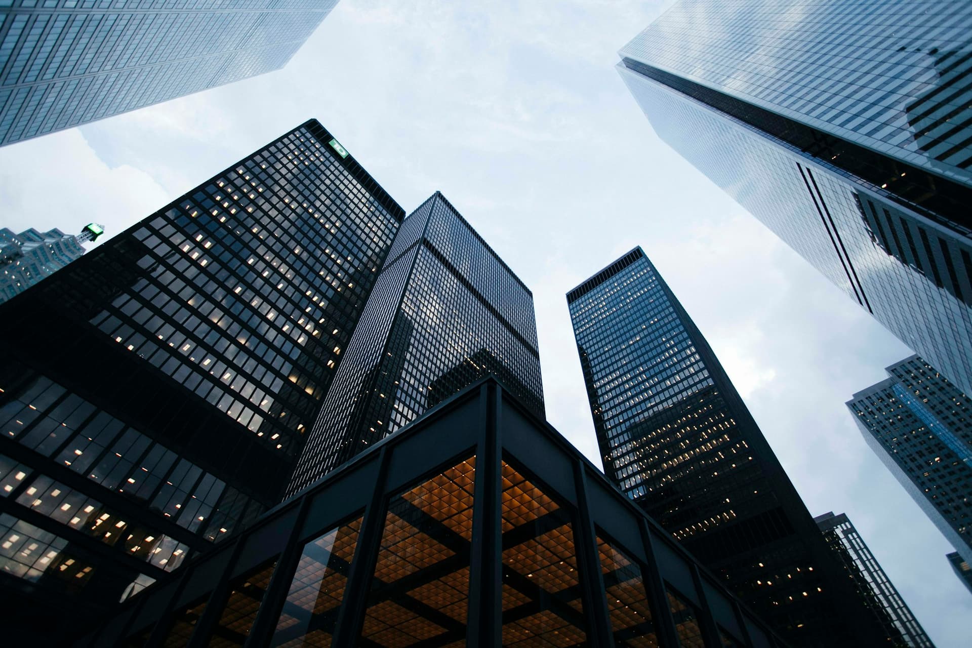 Glass office towers photographed from below against a blue sky